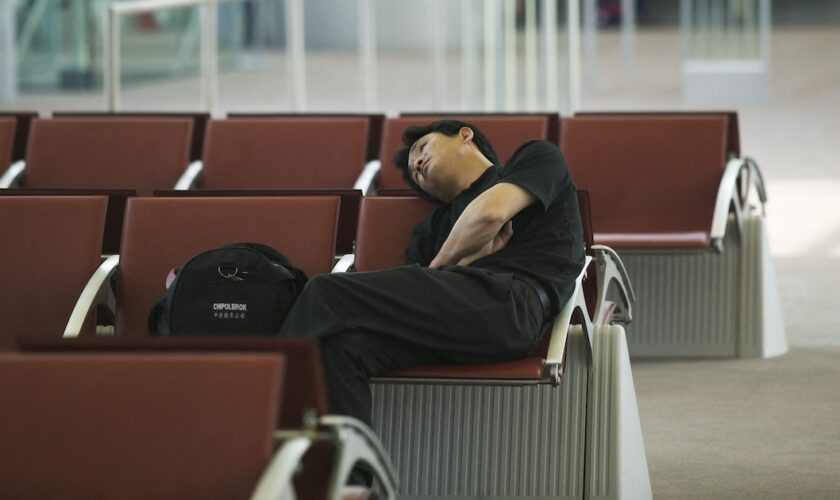 France, Ile-de-France, Seine-et-Marne, Roissy Airport, man sleeping in the waiting lounge. (Photo by Martin/JTP / Photononstop / Photononstop via AFP)