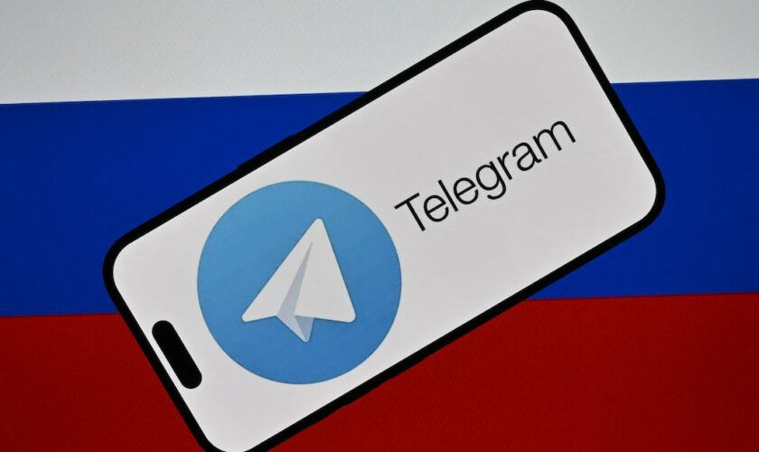 Le logo de la messagerie Telegram devant le drapeau russe.