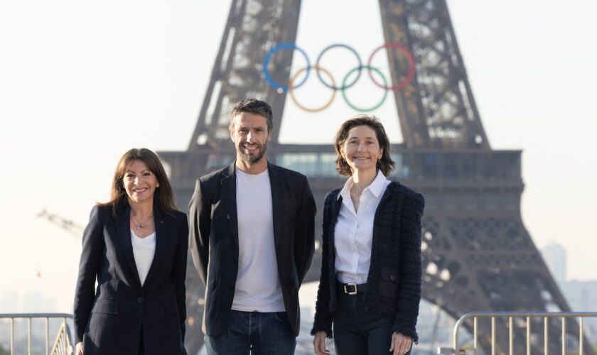 La maire de Paris Anne Hidalgo, le président du Cojo Tony Estanguet et la ministre des Sports et des Jeux olympiques Amélie Oudéa-Castéra, devant la tour Eiffel.