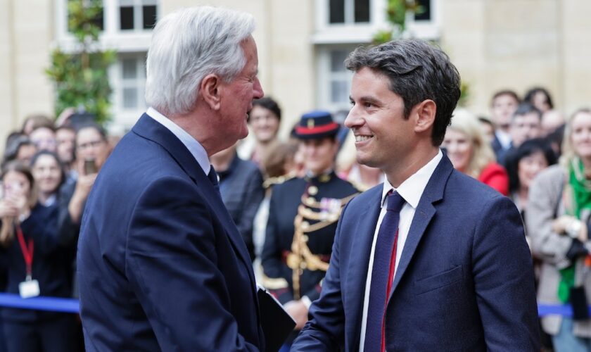 Michel Barnier sert la main du Premier ministre sortant Gabriel Attal lors de la cérémonie de passation de pouvoir à l'Hotel Matignon à Paris, le 5 septembre 2024