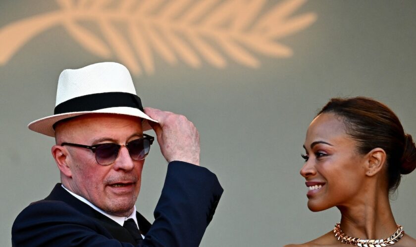 Le réalisateur français Jacques Audiard (g) et l'actrice américaine Zoe Saldana arrivent à la projection du film "Emilia Perez" lors de la 77e édition du Festival de Cannes, dans le sud de la France, le 18 mai 2024