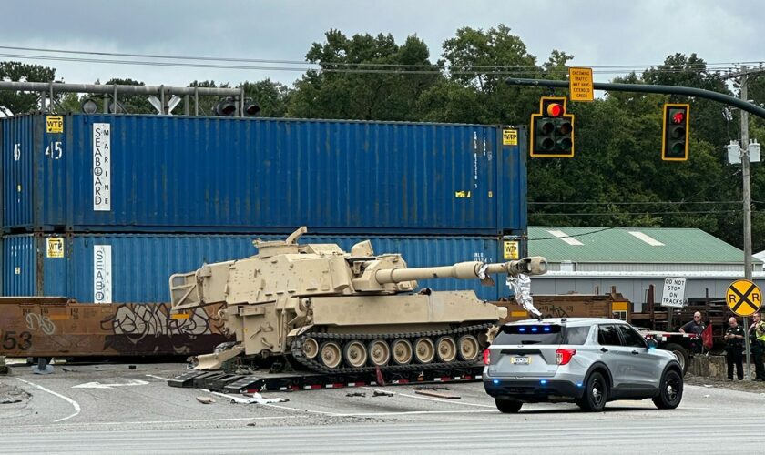 Train collides with military mobile artillery vehicle being hauled on a semi-truck