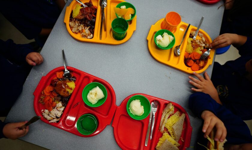 Students eat lunch in the school canteen during the beginning of the roll-out of universal free school meals for primary school children at Ysgol Y Preseli in Pembrokeshire. Most reception pupils in Wales will begin receiving free school meals as they return to school this September. The scheme, which is one of the strands of the Welsh Government's co-operation agreement with Plaid Cymru, is due to be fully rolled out by 2024. Picture date: Wednesday September 7, 2022.