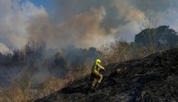 A firefighter works in the area around a fire after the military said it fired interceptors at a missile launched from Yemen that landed in central Israel on Sunday, Sept. 15, 2024. (AP Photo/Ohad Zwigenberg)