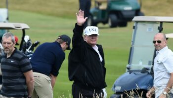 Le président américain Donald Trump (c) sur le parcours de golf de son luxueux complexe hôtelier de Turnberry, le 14 juillet 2018 en Ecosse