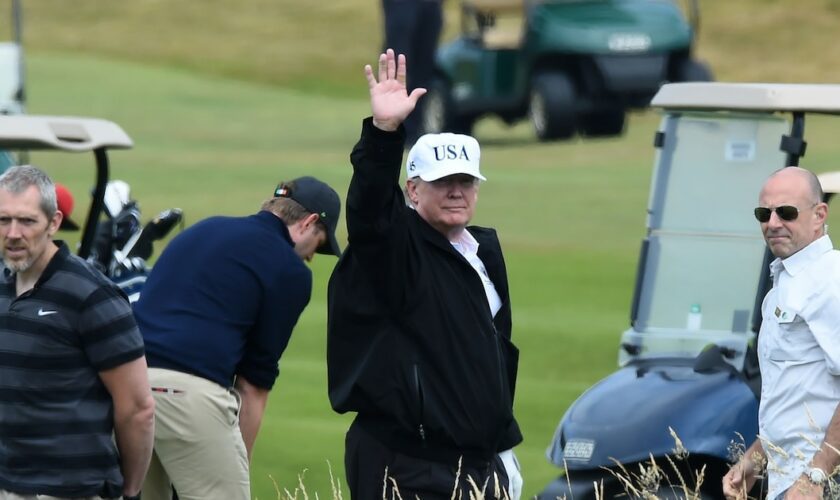 Le président américain Donald Trump (c) sur le parcours de golf de son luxueux complexe hôtelier de Turnberry, le 14 juillet 2018 en Ecosse