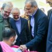 In this photo released by the Iranian Presidency Office, President Masoud Pezeshkian, second right, visits a victim of Lebanon's recent attacks at a hospital in Tehran, Iran, Friday, Sept. 20, 2024. (Iranian Presidency Office via AP)