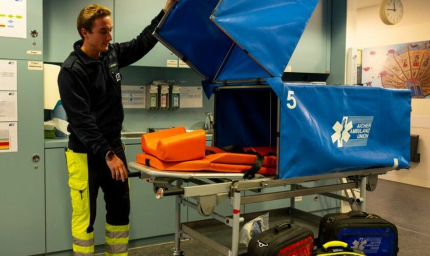 Patienten werden auf der Transporttrage vor neugierigen Blicken geschützt. Foto: Lennart Preiss/dpa