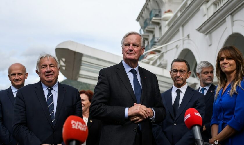 Le Premier ministre français Michel Barnier (C) s'adresse aux journalistes après avoir été accueilli par le chef du groupe parlementaire du parti Les Républicains (LR) au Sénat, à Paris, le 12 septembre 2024