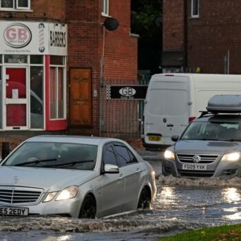 Vehicles drive through flood water in Perry Bar, Birmingham. Pic: PA