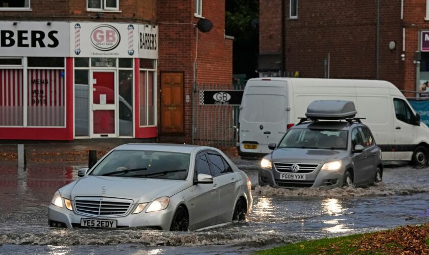 Vehicles drive through flood water in Perry Bar, Birmingham. Pic: PA