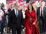 The Red Queen! Vic Starmer makes triumphal entrance to Labour conference in 'loaned' £1,100 designer dress alongside Sir Keir ahead of his speech to party faithful - amid clothing freebies row