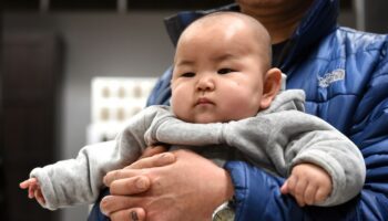 Pour désigner sa mère, un enfant chinois dit "mama". (ici, un enfant dans les bras de son père à Pékin).