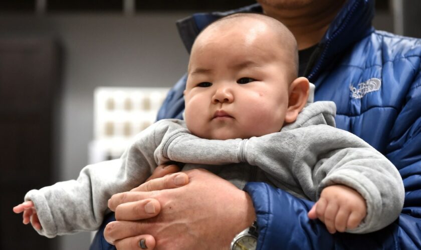 Pour désigner sa mère, un enfant chinois dit "mama". (ici, un enfant dans les bras de son père à Pékin).