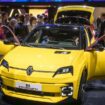 Des visiteurs à côté d'un modèle de voiture électrique Renault R5 E-Tech présenté en première mondiale par le constructeur automobile français lors de la première journée publique du Salon international de l'automobile de Genève, à Genève, le 28 février 2024. (Photo de Fabrice COFFRINI / AFP)