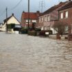 Un homme marche le 3 janvier 2024 dans une rue inondée d'Arques, dans le nord de la France, suite à la crue de l'Aa