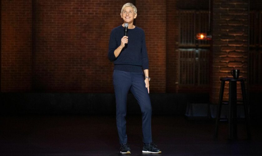 Ellen DeGeneres steht auf einer Bühne und hält ein Mikrophon in der Hand