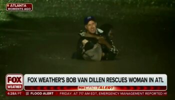 In this image made from a Fox Weather broadcast, meteorologist Bob Van Dillen rescues a woman stuck in floodwaters caused by Hurricane Helene in Atlanta, Friday, Sept. 27, 2024. (Fox Weather via AP)