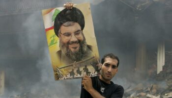 Un Libanais brandit une photo de Hassan Nasrallah après des frappes aériennes israéliennes sur un bastion du Hezbollah à Beyrouth, le 23 juillet 2006