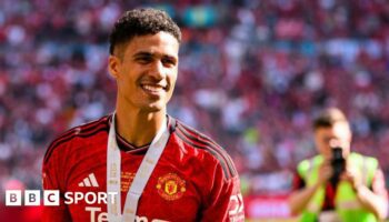 A smiling Raphael Varane at Wembley wearing his FA Cup final winner's medal