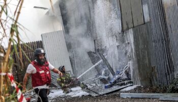 An Israeli firefighter works to put out a fire after a projectile landed at the scene in Kfar Chabad. Pic: Reuters