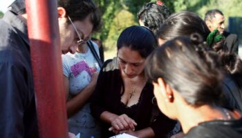 Un membre d'une association récupère l'OQTF de Roms dans un bidonville de Saint-Denis.