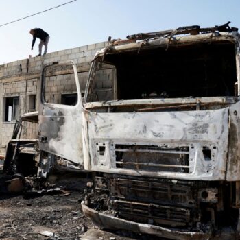 A Palestinian man inspects the damage after Israeli settlers attacked a village in the Israeli-occupied West Bank in April. Pic: Reuters