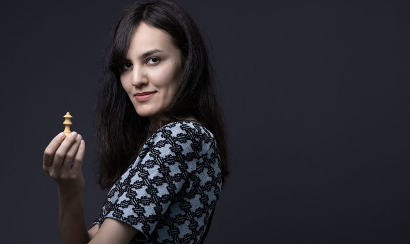 Franco-Iranian chess player Mitra Hejazipour, poses at home with a chess queen in Paris on September 15, 2023. (Photo by JOEL SAGET / AFP)