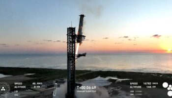 Image de la retransmission vidéo de SpaceX montrant Super Heavy sur le point d'être attrapé par les "baguettes" à son retour à la tour de lancement, le 13 octobre 2024, à Boca Chica (Texas)