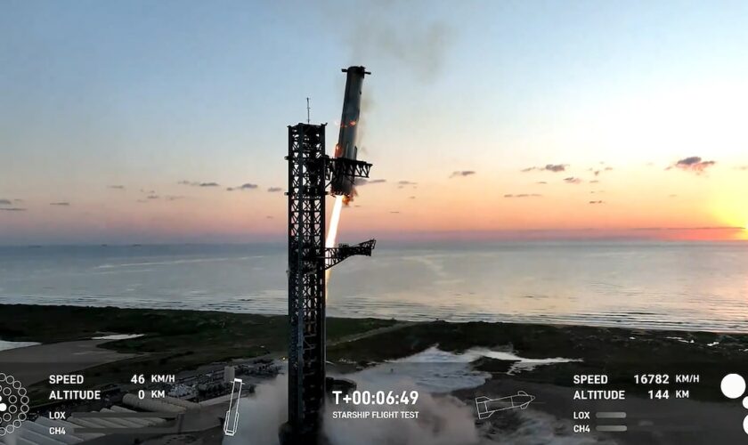 Image de la retransmission vidéo de SpaceX montrant Super Heavy sur le point d'être attrapé par les "baguettes" à son retour à la tour de lancement, le 13 octobre 2024, à Boca Chica (Texas)