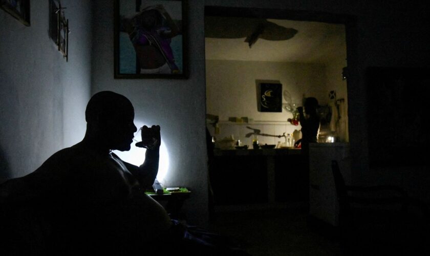 FILE PHOTO: A man drinks water at his home during a power outage caused by breakdowns forcing six plants to go off-line on the grid, according to the state run power company, in Matanzas, Cuba August 22, 2024. REUTERS/Norlys Perez/File Photo