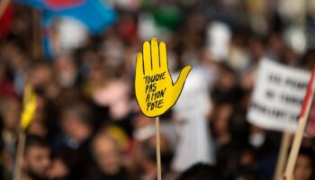 Le logo "Touche pas à mon pote" de SOS Racisme lors d'une manifestation à Paris, le 11 octobre 2015, en mémoire à la centaine de victimes d'un attentat-suicide à Ankara la veille