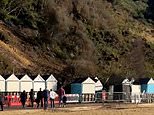 Terrifying moment man comes within inches of being wiped out by flying beach hut as landslide hits popular beach