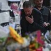 Liam Payne's heartbroken father pauses to kiss pictures of his son at fans' makeshift shrine to One Direction star in Buenos Aires