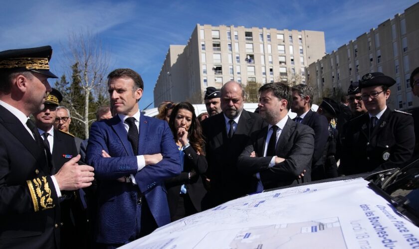 Le président Emmanuel Macron (2e g) et le préfet de police des Bouches-du-Rhône Pierre-Édouard Colliex (g), lors d'une visite axée sur la lutte contre le trafic de drogue dans le quartier de La Castellane, à Marseille, le 19 mars 2024