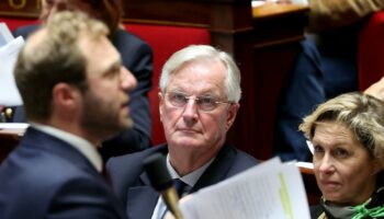 Le Premier ministre français Michel Barnier (c), entouré de la ministre des Relations avec le Parlement Nathalie Delattre (d), écoute le ministre de l'Economie Antoine Armand (g) à l'Assemblée nationale, à Paris, le 15 octobre 2024