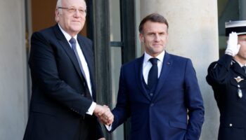 Le président français Emmanuel Macron serre la main du Premier ministre libanais Najib Mikati alors qu'il l'accueille avant leur rencontre au palais présidentiel de l'Élysée à Paris, le 23 octobre 2024.