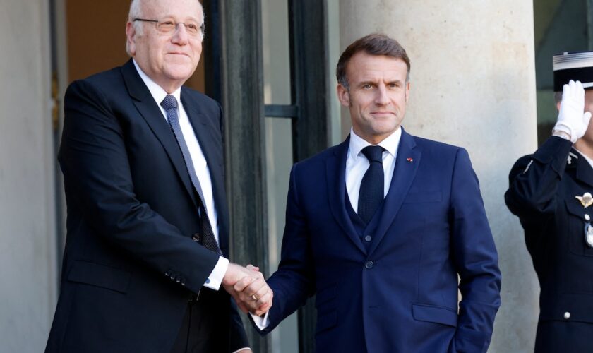 Le président français Emmanuel Macron serre la main du Premier ministre libanais Najib Mikati alors qu'il l'accueille avant leur rencontre au palais présidentiel de l'Élysée à Paris, le 23 octobre 2024.