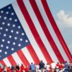 Le drapeau américain flotte au dessus de sympathisants venus assister au meeting où Donald Trump a été la cible de tirs à Butler (nord-est des Etats-Unis), le 13 juillet 2024