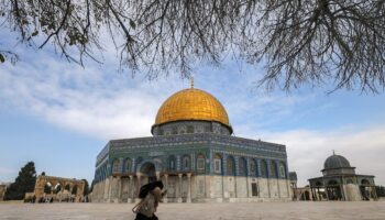 Une femme court devant la mosquée Al-Aqsa, sur l'esplanade des Mosquées, dans la Vieille ville de Jérusalem, dans le secteur palestinien occupé et annexé par Israël, le 3 janvier 2023