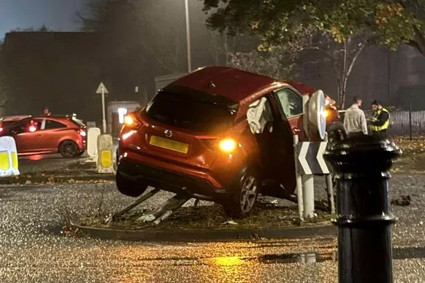 Car left dangling from traffic signs on roundabout after horror crash