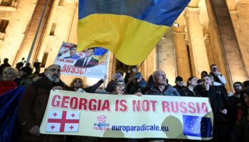 Une banderole "La Géorgie n'est pas la Russie", surmontée d'un drapeau ukrainien, le 28 octobre 2024 dans une manifestation pro-européenne à Tbilissi