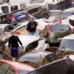 Residents look at cars piled up after being swept away by floods in Valencia, Spain, Wednesday, Oct. 30, 2024. (AP Photo/Alberto Saiz)