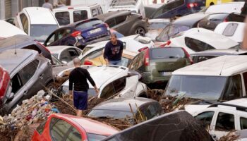 Residents look at cars piled up after being swept away by floods in Valencia, Spain, Wednesday, Oct. 30, 2024. (AP Photo/Alberto Saiz)