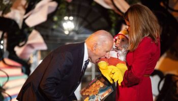 Joe Biden bites baby's leg and sticks tot's foot in his mouth as kids come dressed for Halloween