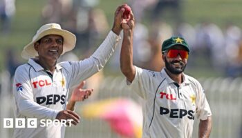 Pakistan spinners Noman Ali (left) and Sajid Khan (right) hold up the ball together as they walk off after dismissing England