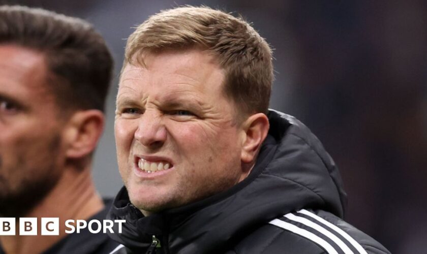 Eddie Howe and one other person talk as they kneel on a pitch