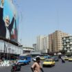 Cars and people on a street in Tehran with a large billboard showing an image of former Hamas leader Ismail Haniyeh (file photo)