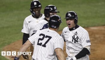 New York Yankees shortstop Anthony Volpe (right) celebrates after hitting a grand slam in game four