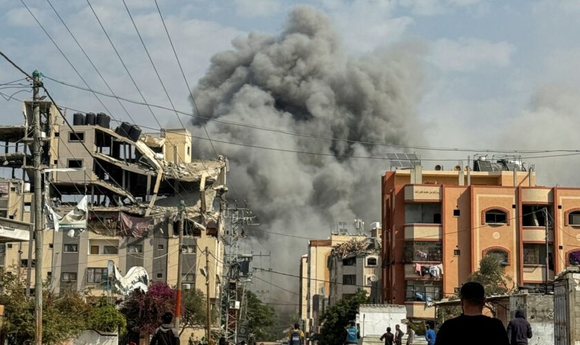 Palestinians watch as smoke rises following Israeli strikes in Nuseirat in the central Gaza Strip. Pic: Reuters